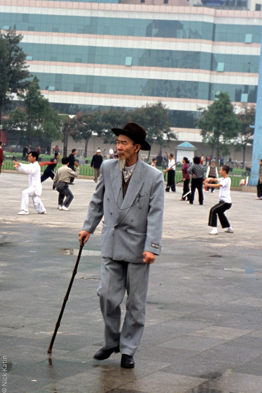 Well dressed man watching Tai Chi in Kunming's main square.