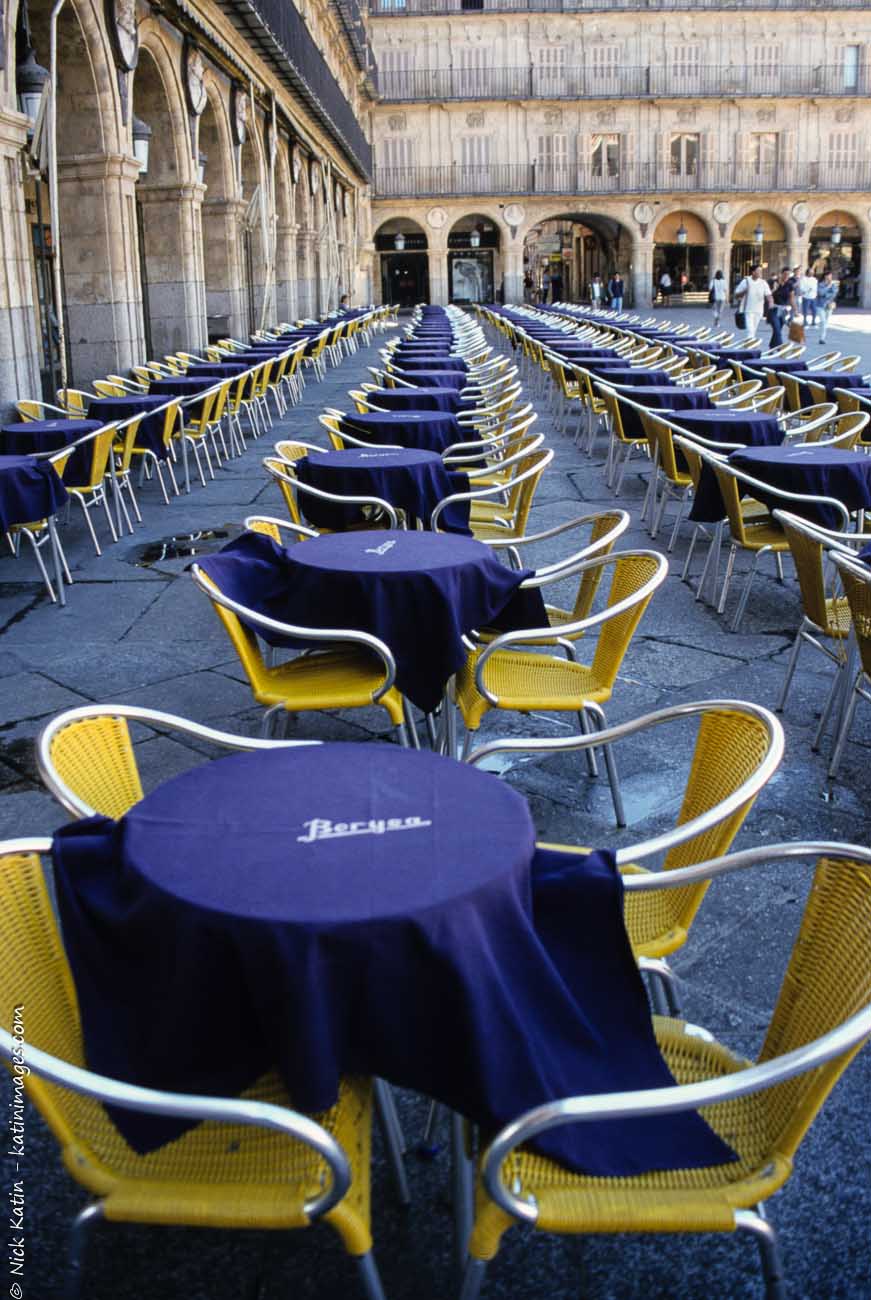 Empty tables waiting for customers at a alfresco restaurant, in Salamanca's Plaza Mayor in Spain