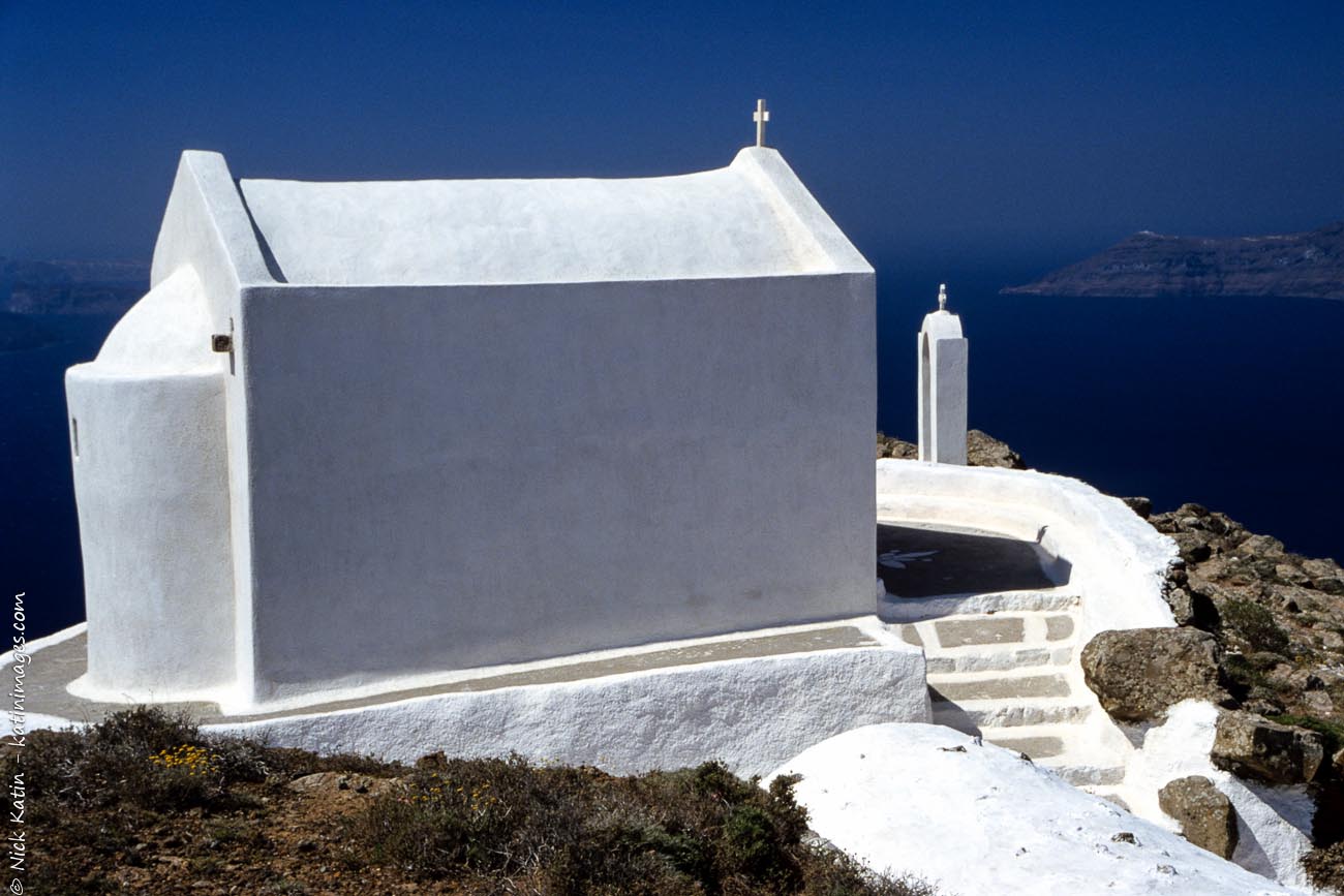 A small church sitting on the cliffside in Santorini, Greece