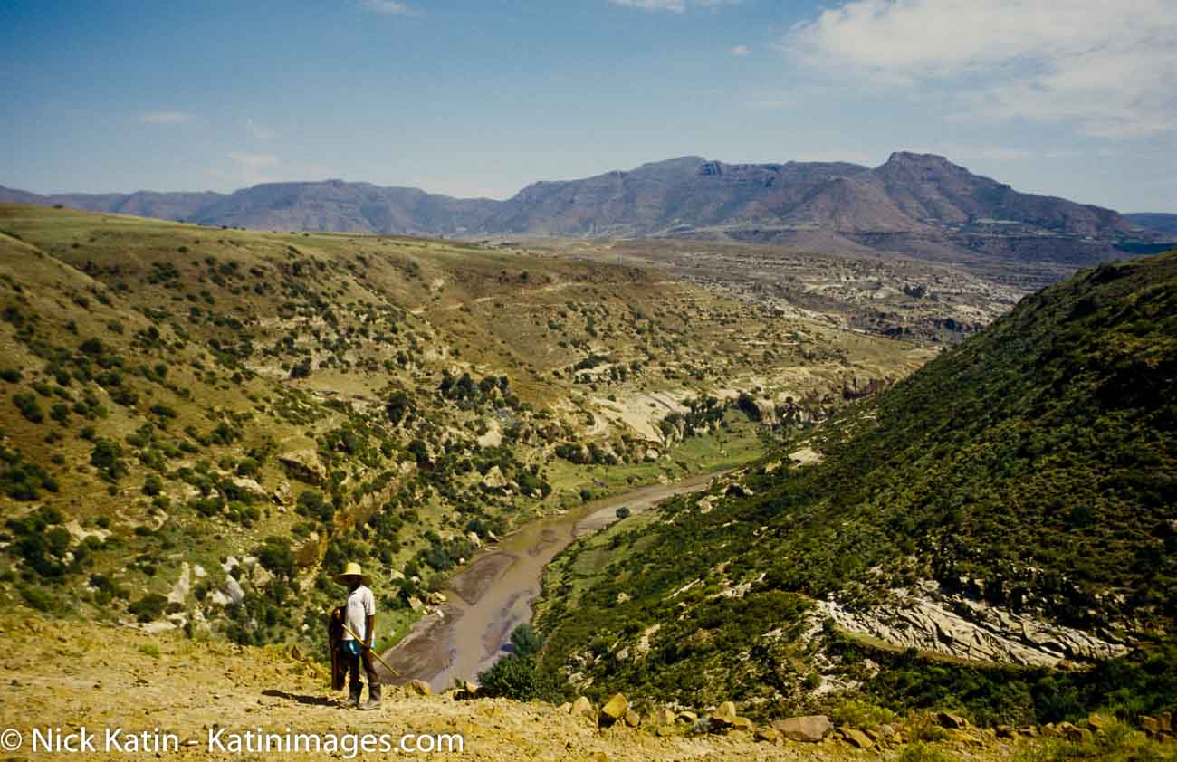 A sheep herder stands overlooking a gorge in the Maloti Mountains of Lesotho.